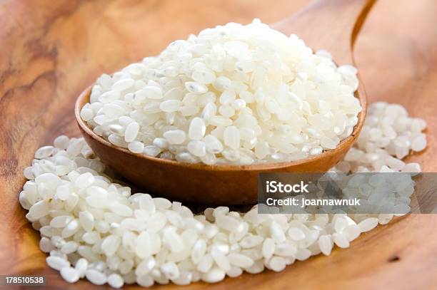 Foto de Arroz Na Colher De Madeira Sobre A Kitchen Table e mais fotos de stock de Amontoamento - Amontoamento, Arroz - Alimento básico, Arroz - Cereal