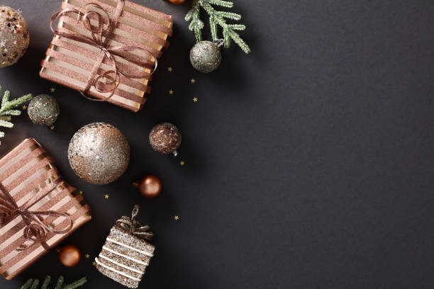 istock Elegant Christmas composition with bronze gift boxes and baubles on black background with and copy space. Festive holiday design for greeting card or poster. 1785108822