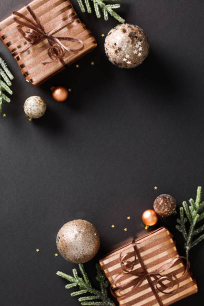 istock Elegant Christmas composition with bronze gift boxes, ornaments, and festive confetti on a dark background. Luxury holiday concept with copy space 1785109622
