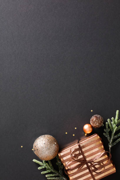 istock Stylish Christmas vertical banner featuring a bronze gift box on a dark background. Elegant decoration and festive concept with copy space 1785113589