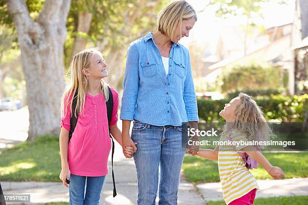 Mother And Daughters Walking On Suburban Street Stock Photo - Download Image Now - Family, Residential District, Walking
