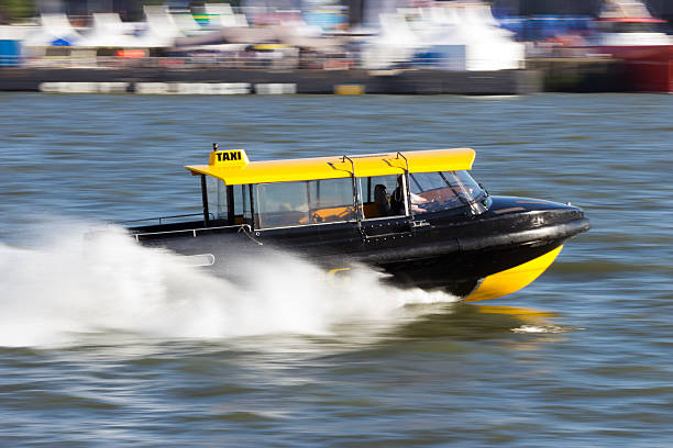 water taxi "Water taxi speeding over the Meiuse river in Rotterdam, The Netherlands" watertaxi stock pictures, royalty-free photos & images