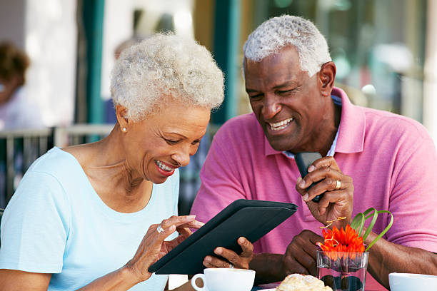 couple senior à l'aide d'une tablette dans le café en plein air - women telephone senior adult on the phone photos et images de collection