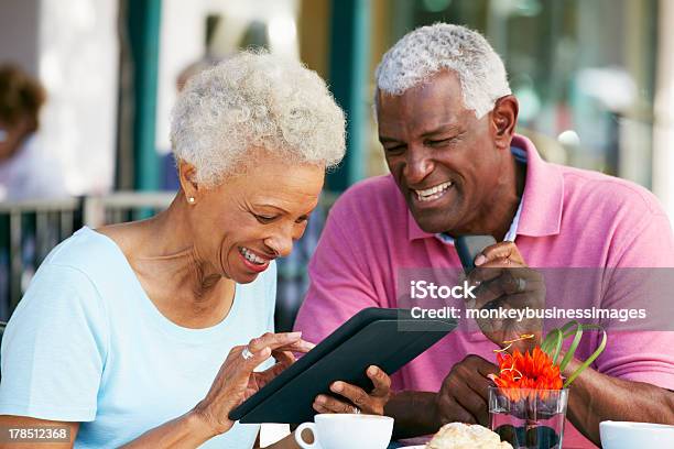 年配のカップルでタブレットコンピューターを使用して屋外カフェ - シニア世代のストックフォトや画像を多数ご用意 - シニア世代, 携帯電話, アフリカ系アメリカ人