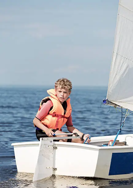 The boy operates the yacht
