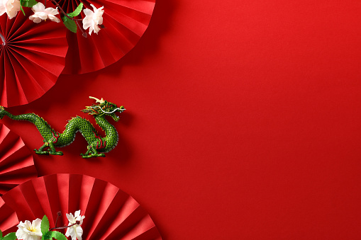 Abstract Chinese New Year 2024 Art - Festive Dragon with folding paper fans and sakura on red background