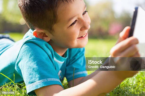 Little Boy Using Digital Tablet Stock Photo - Download Image Now - Child, Grass, Using Digital Tablet