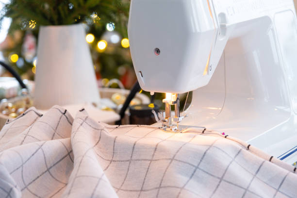 istock Sewing process on a sewing machine, a needle with a thread and a holder close-up stitch the white checkered fabric. Preparation for Christmas and new year, textiles for cozy in festive decor interior 1785143680