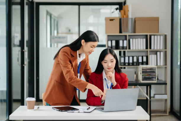 istock Asian working together on a project two young business colleagues working 1785145945