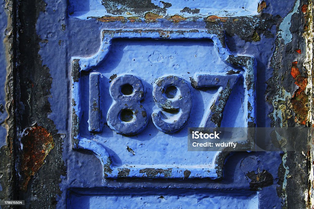 Rugged rusted surface with a strong date stamp on it. 1897 Stock Photo