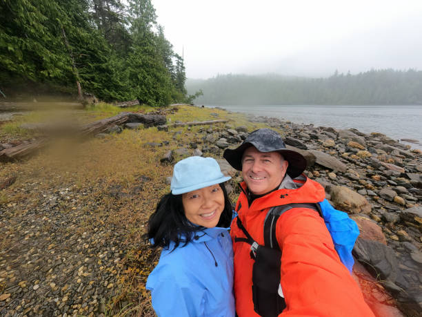 Senior Multiracial Couple Taking Selfie on Wilderness Beach While Hiking
