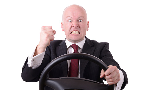 road rage behind the wheel with clenched fist isolated on white background