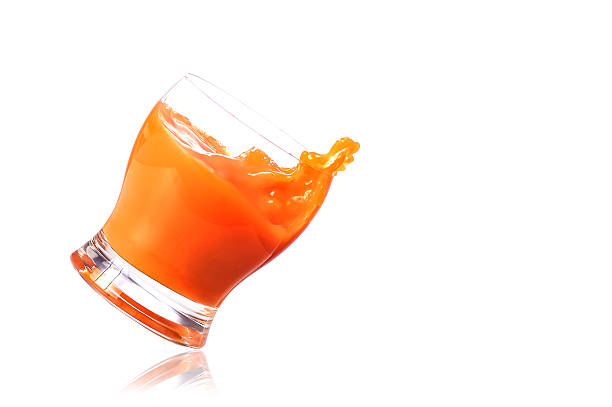 Pouring Squash into Glass of Water close up with a white background.