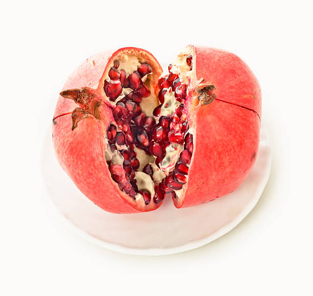 Pomegranate on a white plate stock photo