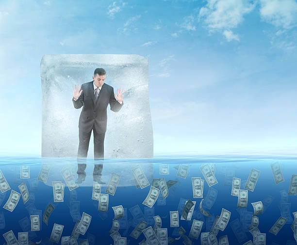 кубик льда с бизнесмен плавающая в море - frozen currency finance ice стоковые фото и изображения