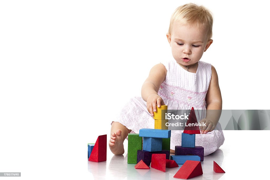 Beautiful baby building a castle Beautiful baby building a castle with cubes isolated on white Achievement Stock Photo