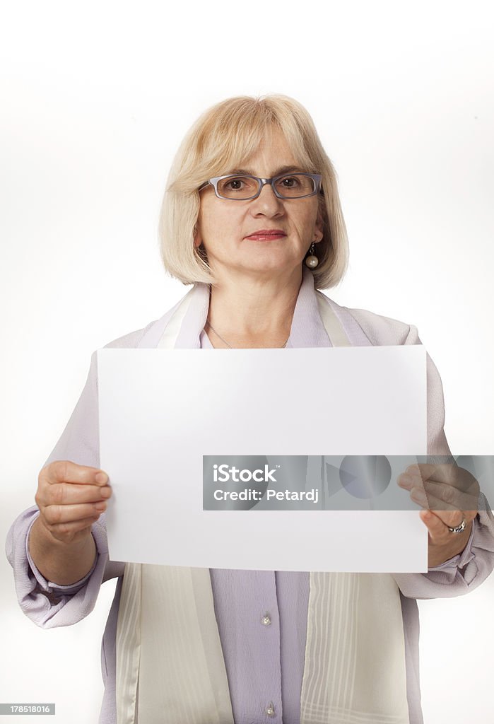 Пожилые Женщина держит белый картон - Стоковые фото 55-59 лет роялти-фри