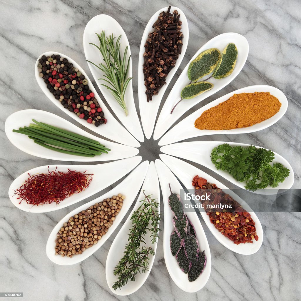Herbs and Spices Herb and spice selection in white porcelain dishes over marble background. Black Peppercorn Stock Photo