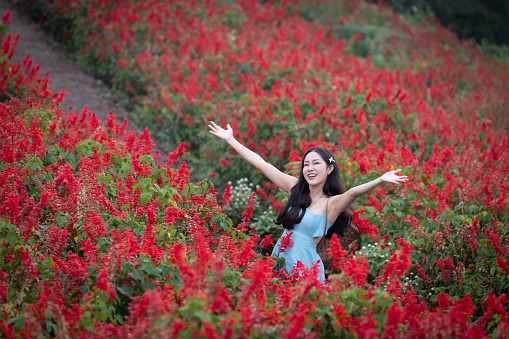 Flower gardens are often associated with tranquility and enjoyment. The women in this setting might be appreciating the beauty of the flowers, engaging in leisurely activities, or simply enjoying the serene atmosphere.