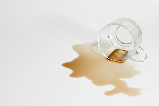 Spilled drink glass spread on a white background