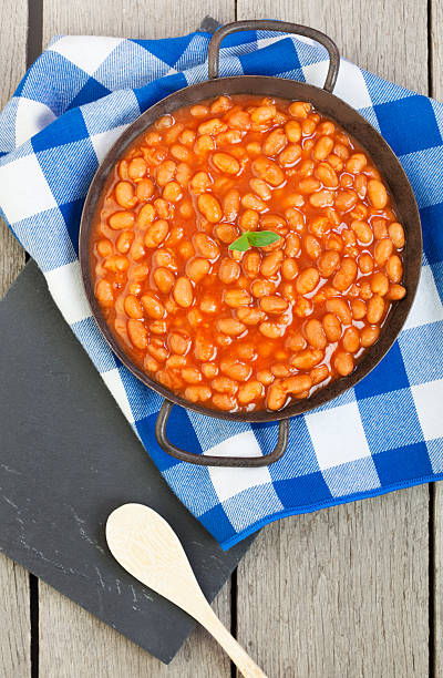 Baked Beans Classic baked beans in a rustic antique pan. baked beans stock pictures, royalty-free photos & images
