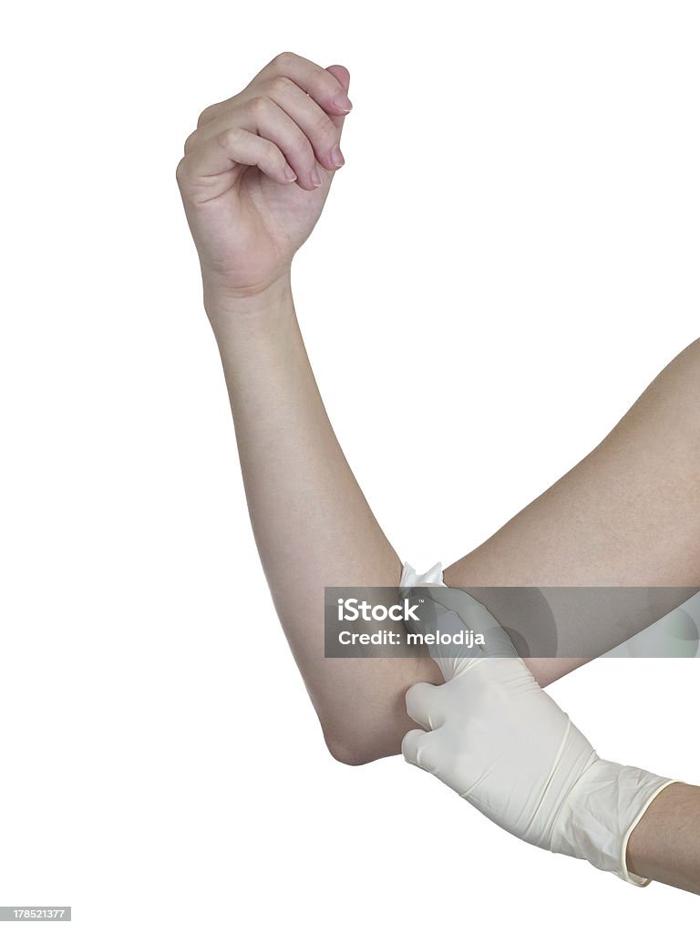 Mão pressionando gaze no braço depois de administrar uma injeção. - Foto de stock de Adulto royalty-free