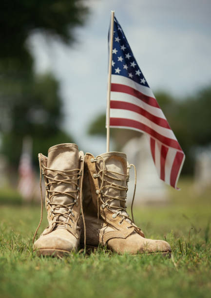 Old military combat boots against American flag Old military combat boots against American flag in the background. Memorial Day or Veterans Day, sacrifice concept. usa flag shoes stock pictures, royalty-free photos & images