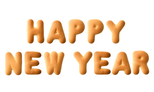 Close-up of HAPPY NEW YEAR written with alphabet biscuit on white background.