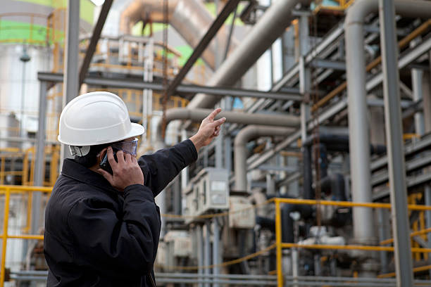 oil refinery engineer oil refinery engineer pointing against pipelinemy collection lightbox power plant workers stock pictures, royalty-free photos & images