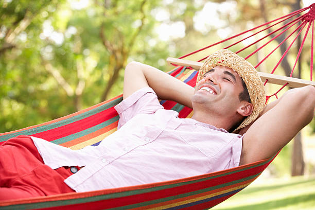 istock A man in a hat relaxing on a hammock outdoors 178523011