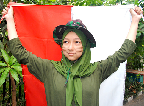 A hijab girl is holding an Indonesian flag in National Heroes Day.