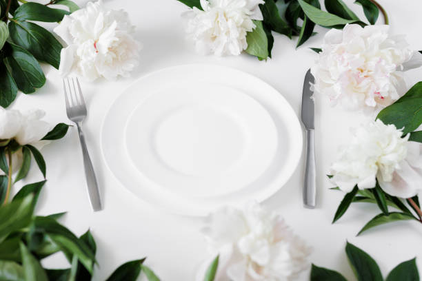 istock Festive table setting with white plate, cutlery and peonies on white table 1785236506