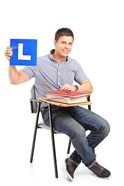 istock Student sitting on a school chair and holding L plate 178524263