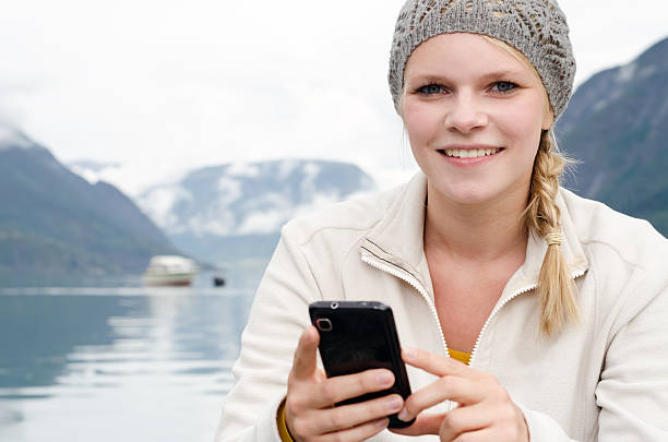 young blond woman with her Smartphone in the hand stock photo