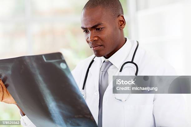 Afroamericano Médico Olhando Para A Radiografia Do Doente - Fotografias de stock e mais imagens de Adulto