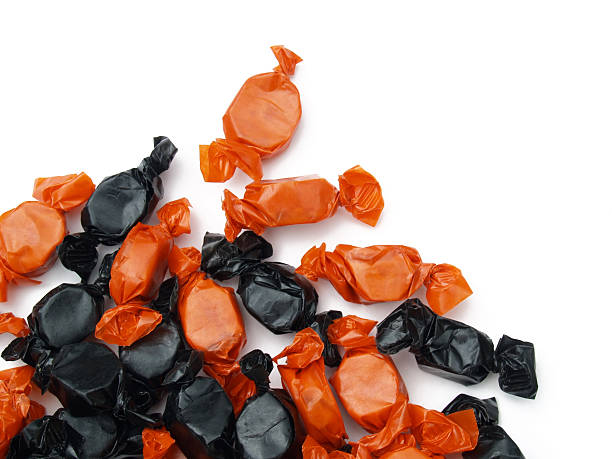 Black and orange wrapped sweets on white background stock photo