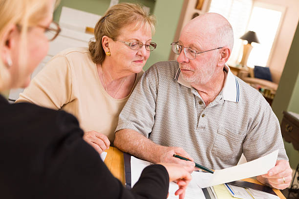 istock Senior couple discussing paperwork with their agent 178526050