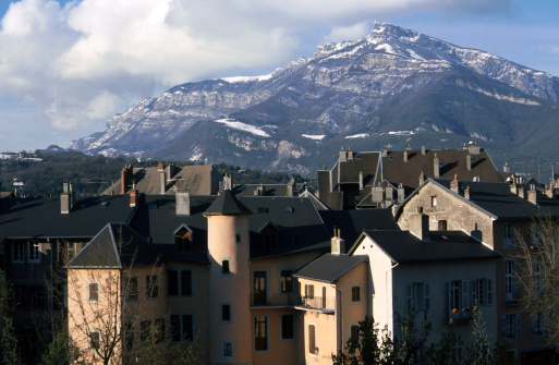 Old city of Chambery, in Savoy, France. View of medieval roofs and snowed mountains.