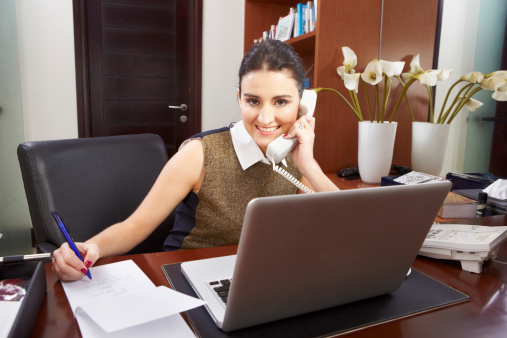 young woman working multitasking in the office alone