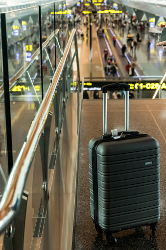 Lost or unattended grey suitcase luggage in airport terminal. Travel and safety concept