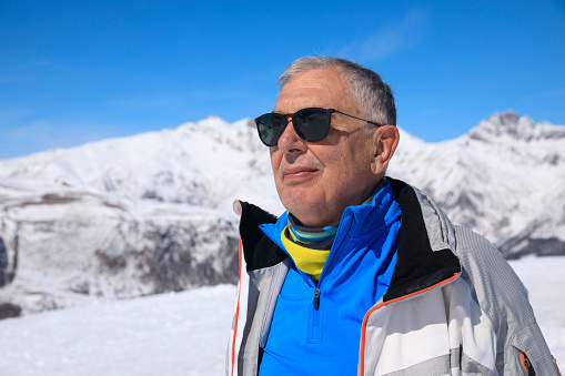 Active lifestyle, Portrait Vital senior  men snow skier, enjoying on sunny ski resorts.  Snowcapped mountain  Alps  ski area. Ski resort Livigno. italy, Europe. Ski opening.