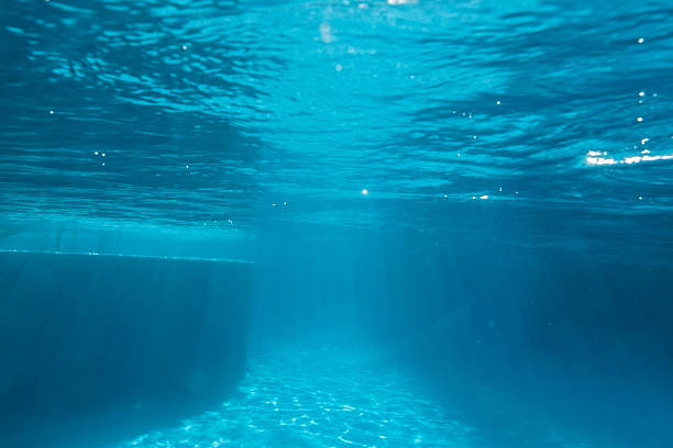 Underwater swimming pool ledge with sunbeam patterns.