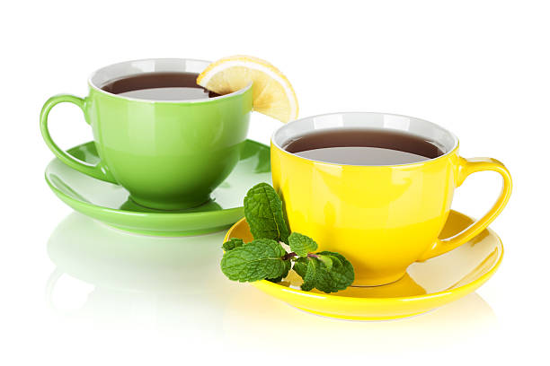colorido dois copos de chá com limão e hortelã - two objects cup saucer isolated imagens e fotografias de stock