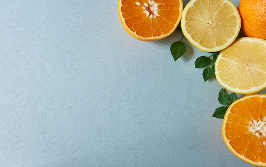 Lemon, orange and grapefruit on blue background with copy space.