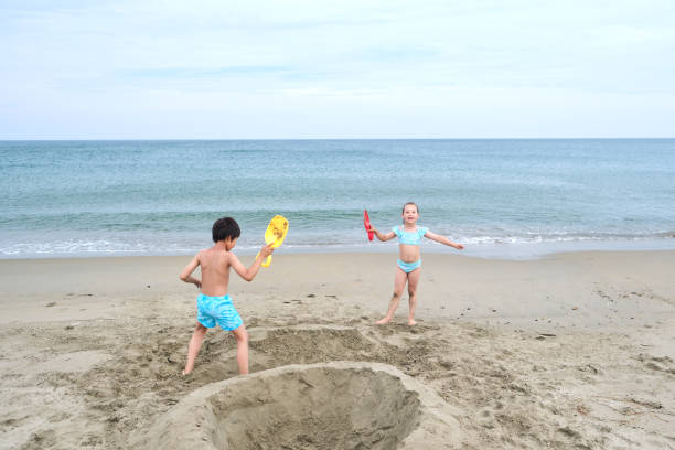 istock Children dig a hole in the sand on the seashore. 1785293537