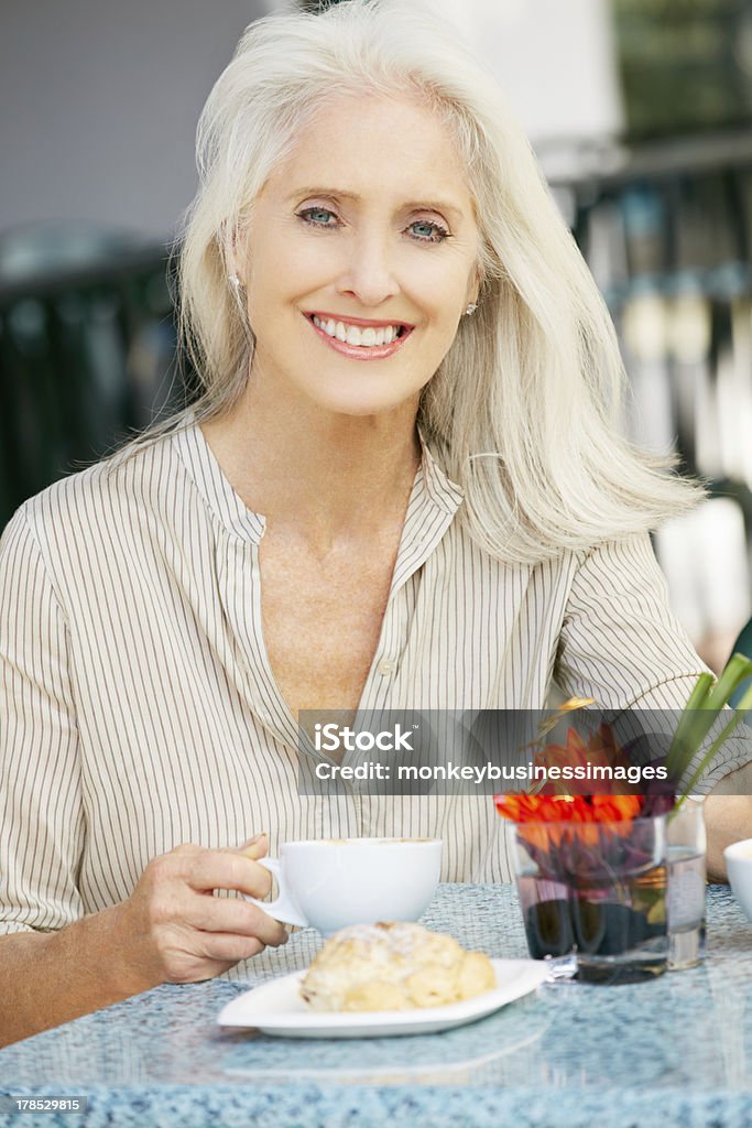 Starszy kobieta zadowolony z przekąskami w kawiarni na świeżym powietrzu - Zbiór zdjęć royalty-free (Kobiety)