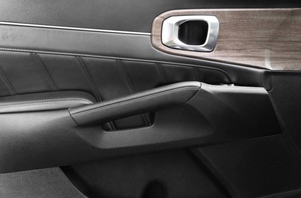 istock Door handle with power window control buttons of a luxury passenger car. Black perforated leather interior with stitching. Modern car black leather interior details. 1785299033