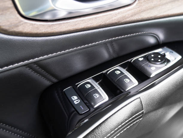 istock Door handle with power window control buttons of a luxury passenger car. Black perforated leather interior with stitching. Modern car black leather interior details. 1785301898