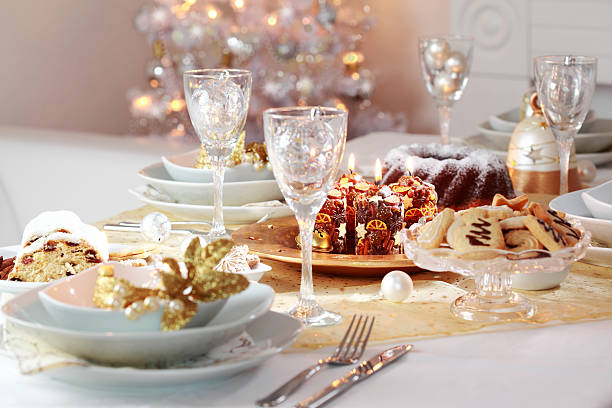 A decorated Christmas table for dinner Decorated Christmas table with tree in background formal dinning stock pictures, royalty-free photos & images