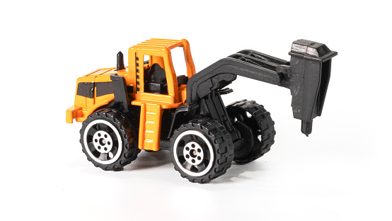 High quality photo. Tractor toy for road works. Construction Equipment Toys isolated on white.
